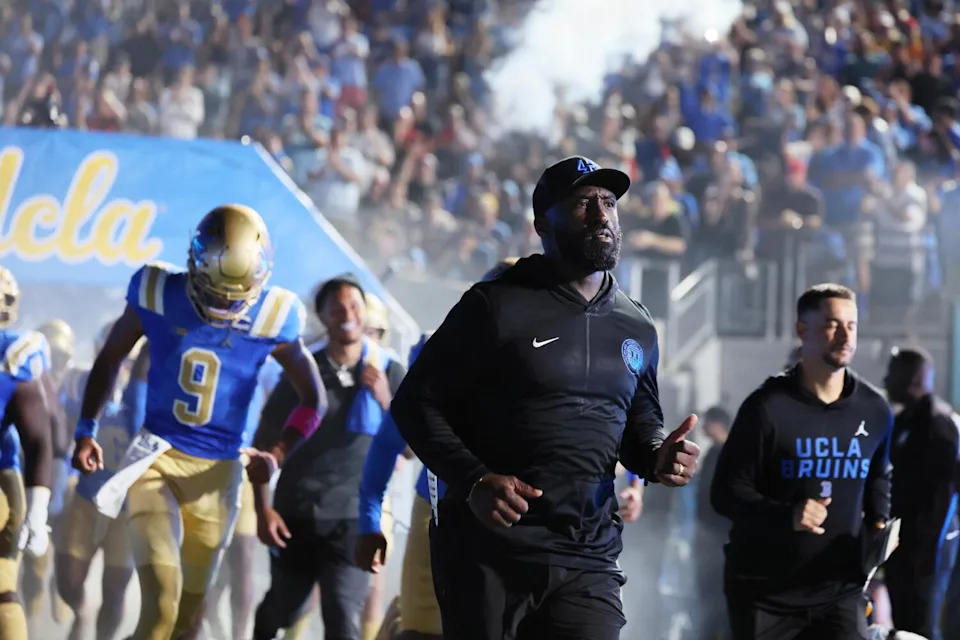 UCLA coach DeShaun Foster runs onto the field before Saturday's loss to Utah at the Rose Bowl.