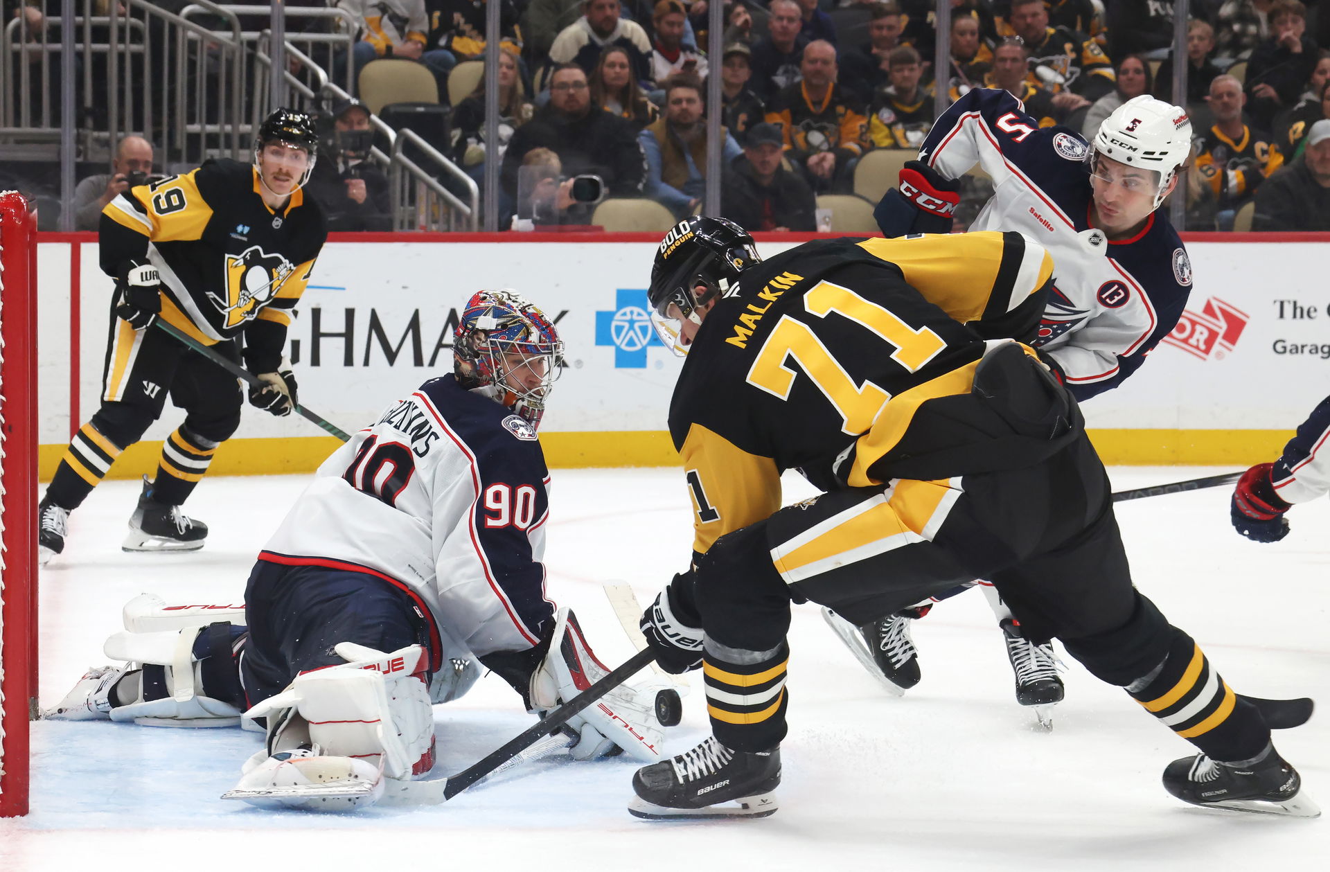 Mar 21, 2025; Pittsburgh, Pennsylvania, USA; Columbus Blue Jackets goaltender Elvis Merzlikins (90) makes a save against Pittsburgh Penguins center Evgeni Malkin (71) during the third period at PPG Paints Arena. (Charles LeClaire-Imagn Images)