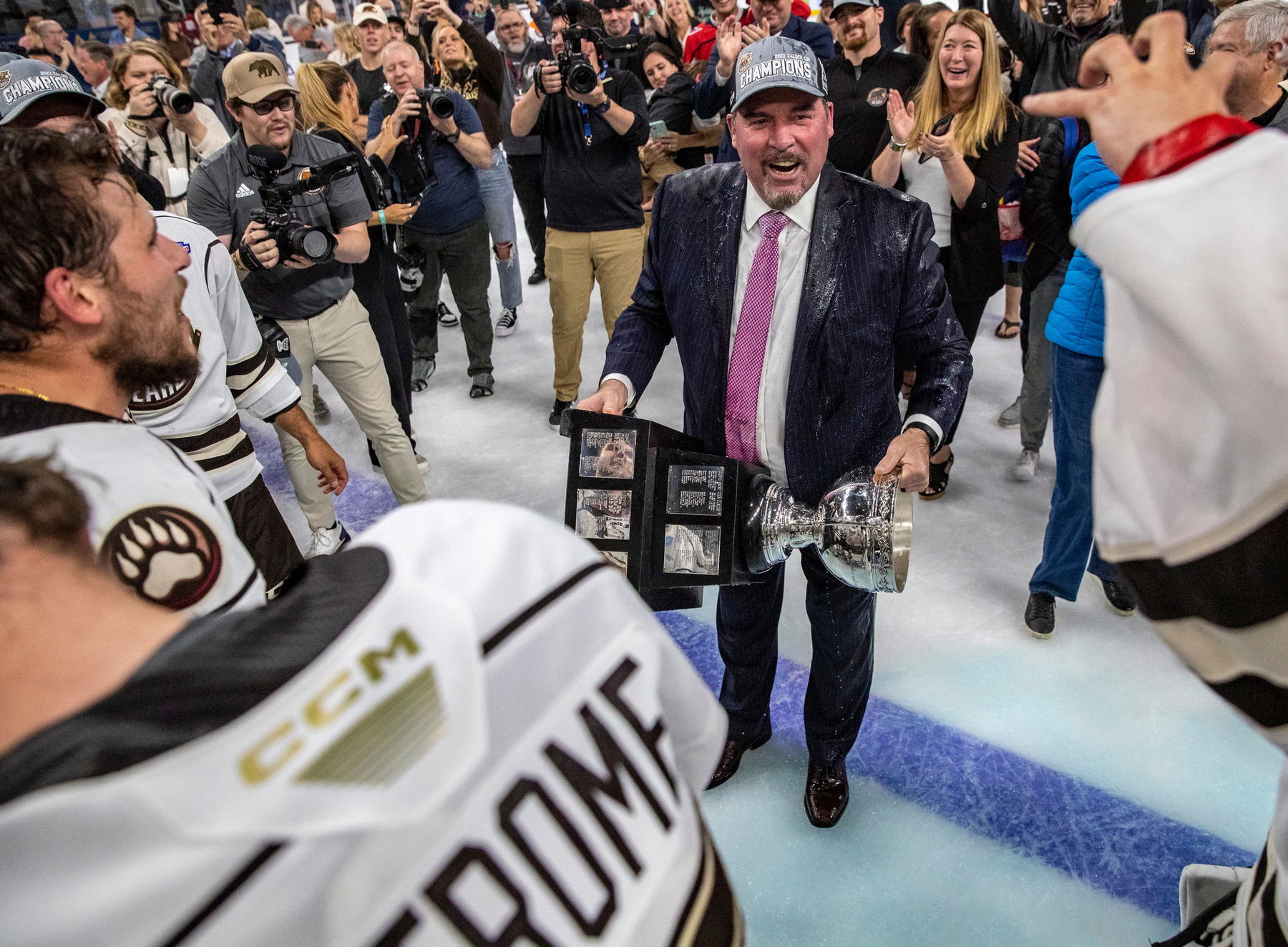 Hershey Bears head coach Todd Nelson is soaked by his players as he holds the Calder Memorial trophy after winning Game 7 of the Calder Cup Finals at Acrisure Arena in Palm Desert, Calif., Wednesday, June 21, 2023. (Credit: Andy Abeyta/The Desert Sun / USA TODAY NETWORK)