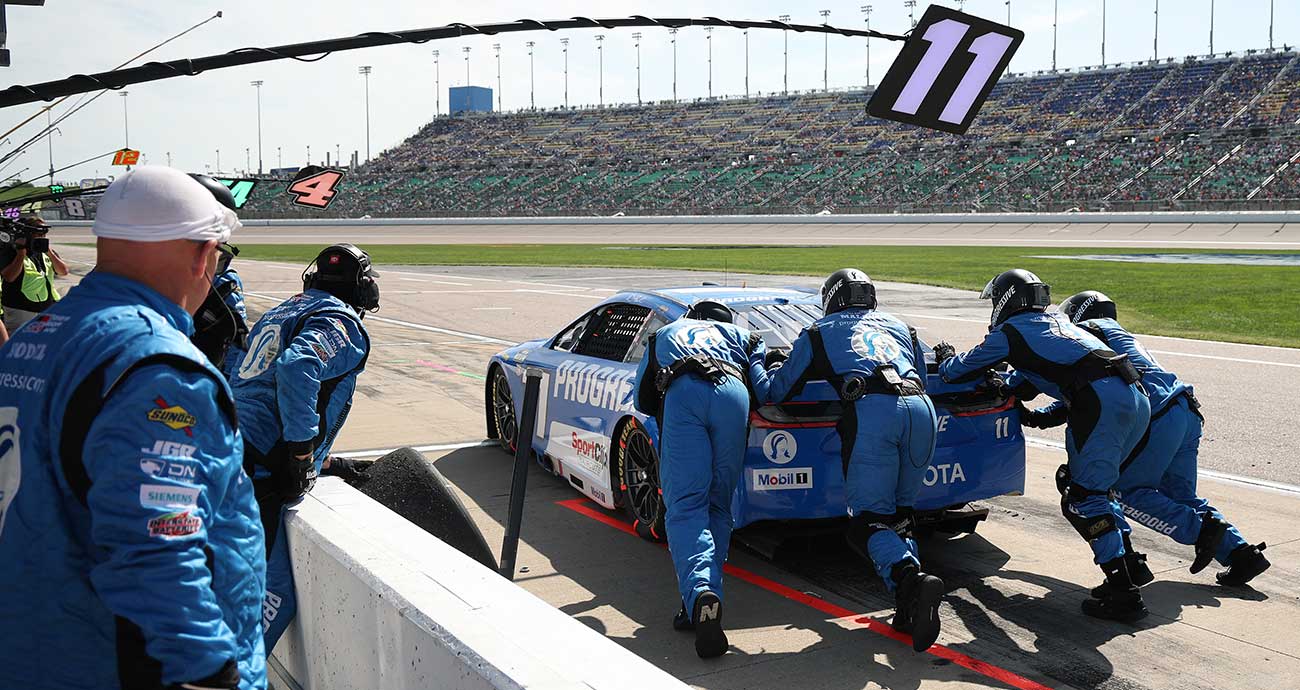 The No. 11 crew gives Denny Hamlin a push out of his pit stall at Kansas Speedway