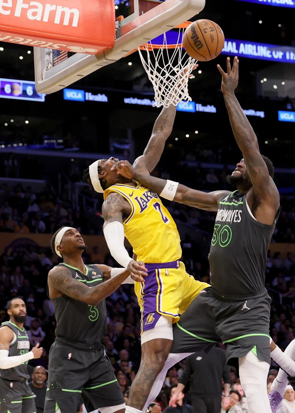 Timberwolves forward Julius Randle scores while putting his hand on the face of Lakers forward Jarred Vanderbilt