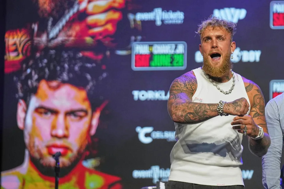 Boxer Jake Paul swings his arm in the air after challenging Julio César Chávez Jr., during a news conference.