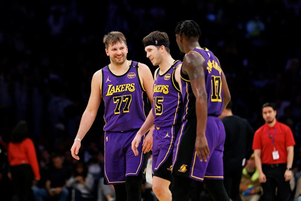 Luka Doncic, left, walks off the court during a timeout with Laker teammates Austin Reaves, center, and Dorian Finney-Smith.