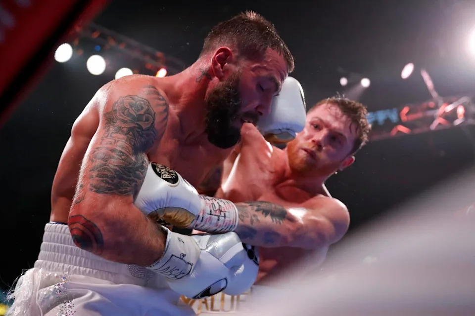 Saúl "Canelo" Álvarez leans over and jabs Caleb Plant in the face during a super middleweight title unification bout in 2021.