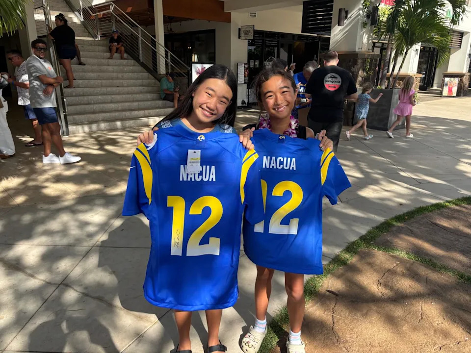 Kiara Nishimura, left, and Peyton Koerte of Kauai hold up jerseys autographed by Puka Nacua.