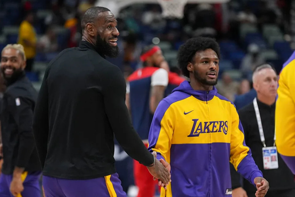 Lakers forward LeBron James greets his son and teammate Bronny James, right, during warm-ups.