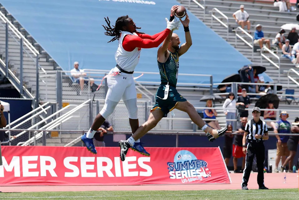 U.S. wide receiver Laval Davis, left, attempts to catch a pass as an Australian player defends.