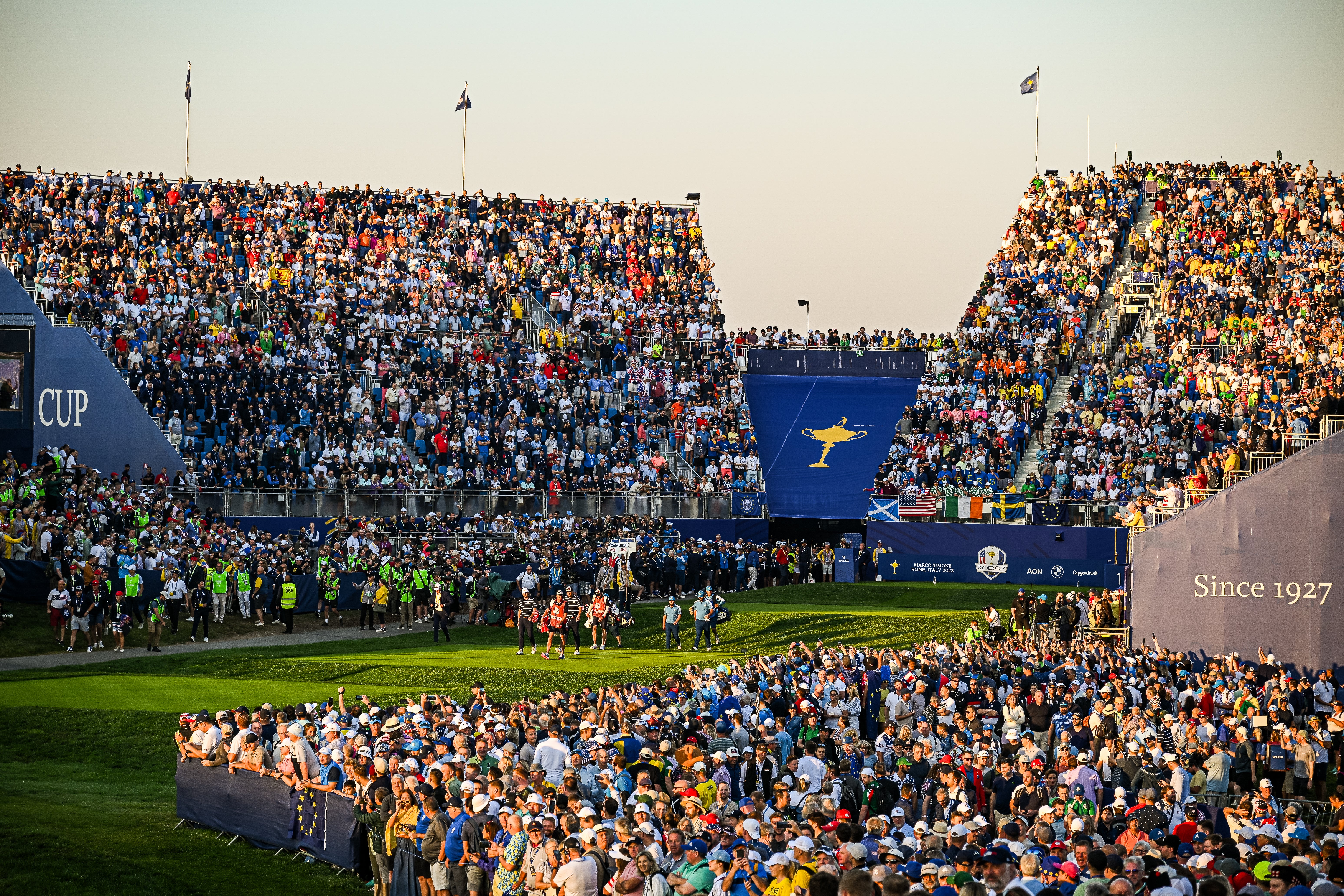 Tyrrell Hatton and Jon Rahm of Team Europe and Scottie Scheffler and Sam Burns of Team United States walk from the first tee