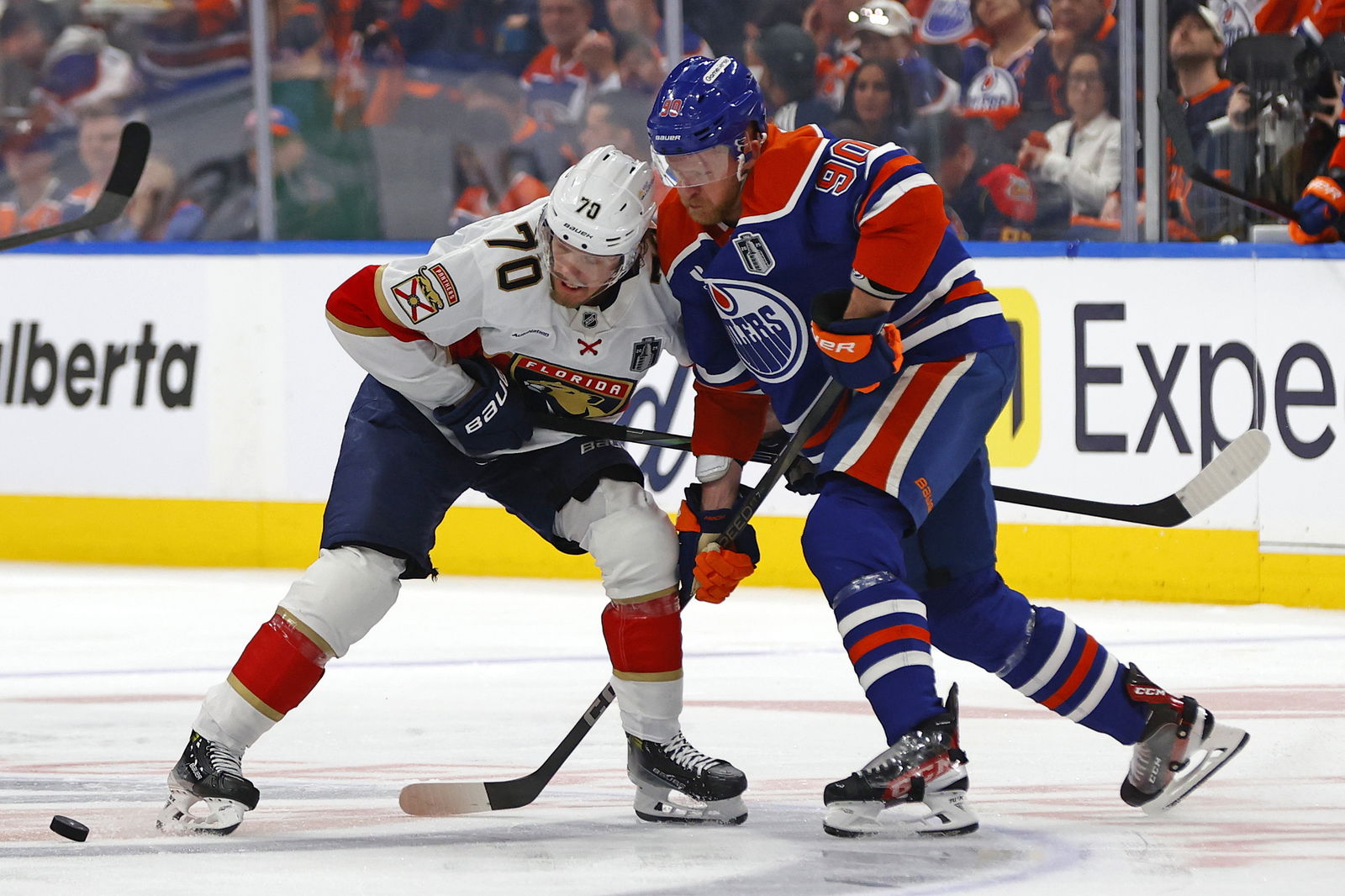 Jun 4, 2025; Edmonton, Alberta, CAN;Florida Panthers center Jesper Boqvist (70) and Edmonton Oilers right wing Corey Perry (90) attempt to get a loose puck in the second period in game one of the 2025 Stanley Cup Final at Rogers Place. Mandatory Credit: Perry Nelson-Imagn Images