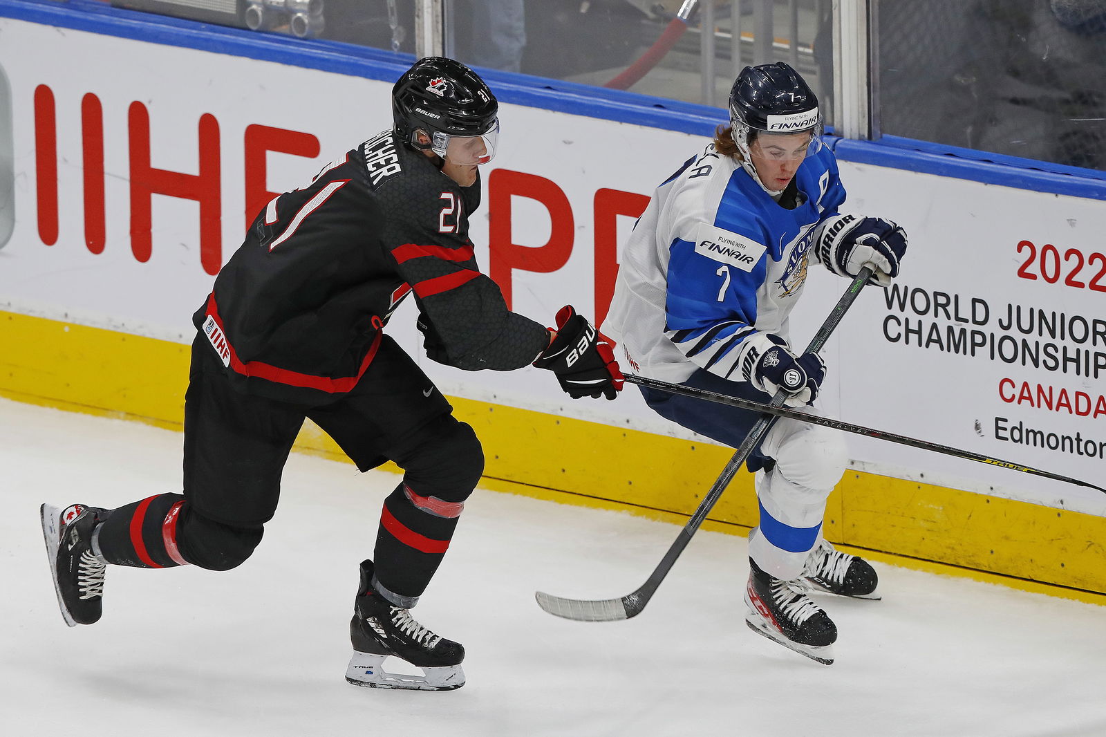 Aug 20, 2022; Edmonton, Alberta, CAN; Team Canada forward Nathan Gaucher (21) and Team Finland defensemen Topi Niemela (7) chase a loose puck during the first period in the championship game during the IIHF U20 Ice Hockey World Championship at Rogers Place. Mandatory Credit: Perry Nelson-Imagn Images