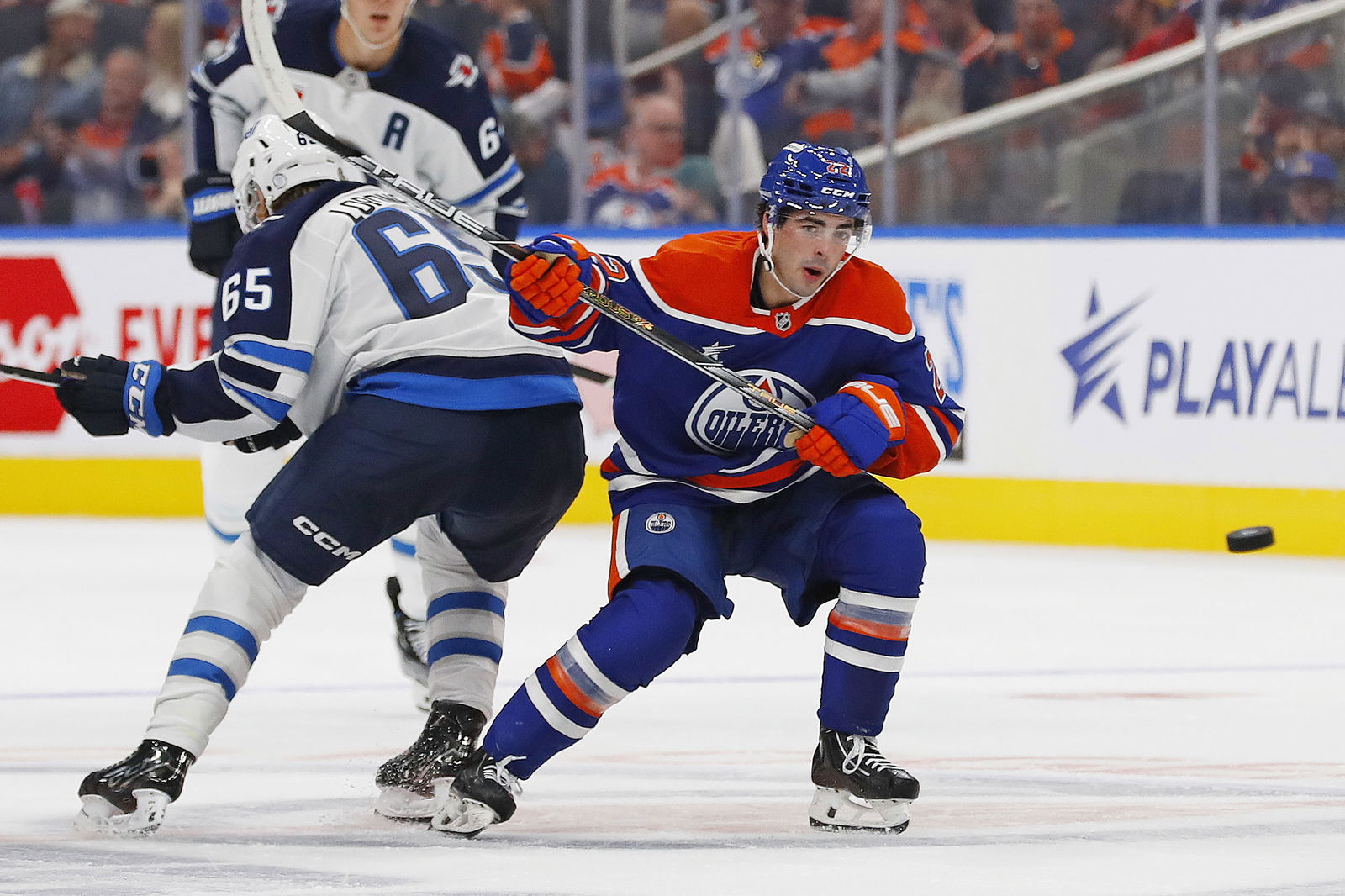 Sep 22, 2024; Edmonton, Alberta, CAN; Edmonton Oilers Forward Matt Savoie (22) battles with Winnipeg Jets forward Markus Loponen (65) while keeping an eye on a loose puck at Rogers Place. Mandatory Credit: Perry Nelson-Imagn Images