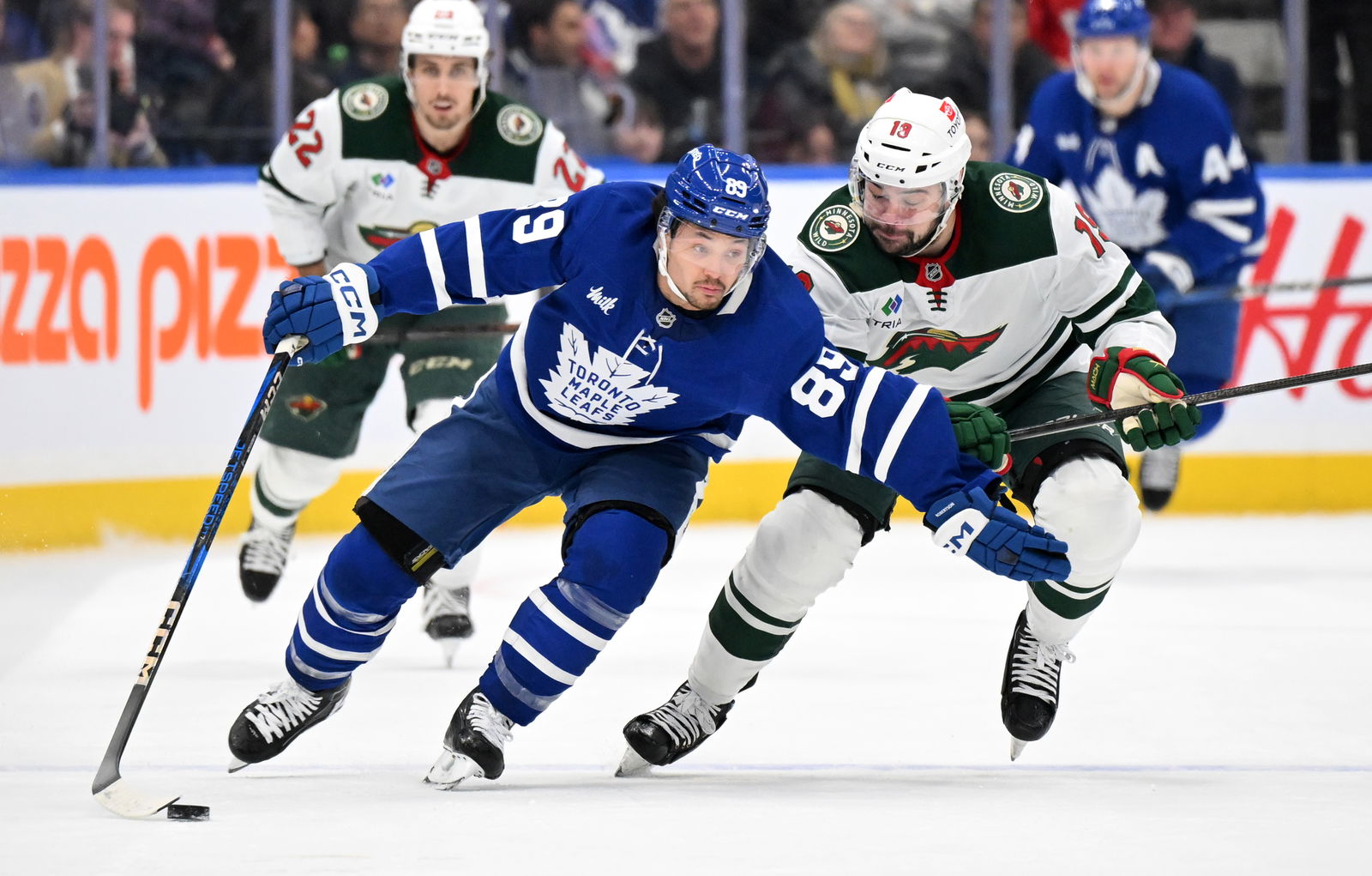 Jan 29, 2025; Toronto, Ontario, CAN; Toronto Maple Leafs forward Nick Robertson (89) skates with the puck against Minnesota Wild forward Devin Shore (19) in the first period at Scotiabank Arena. Mandatory Credit: Dan Hamilton-Imagn Images