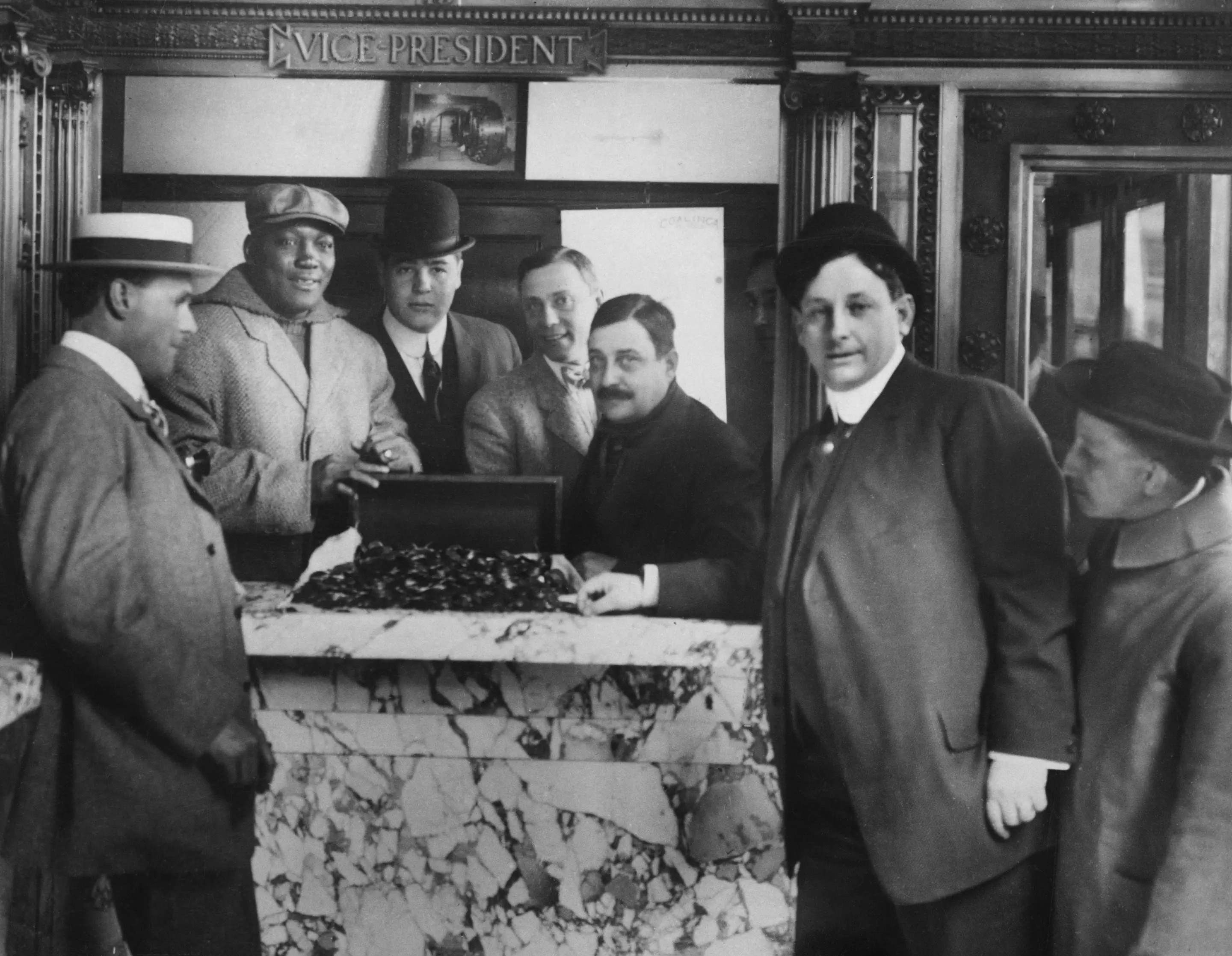American boxing promoter Tex Rickard, American boxer Jack Johnson, American boxer James J Jeffries, and American boxing promoter Jack Gleason, Rickard's business partner, posing with the 20 gold pieces given as a bonus to the fighters for agreeing to the fight, at Reno, Nevada, December 1909. Johnson won the fight, dubbed the 'Fight of the Century', with a 15th-round knockout. (Photo by Keystone View Company/FPG/Archive Photos/Getty Images)