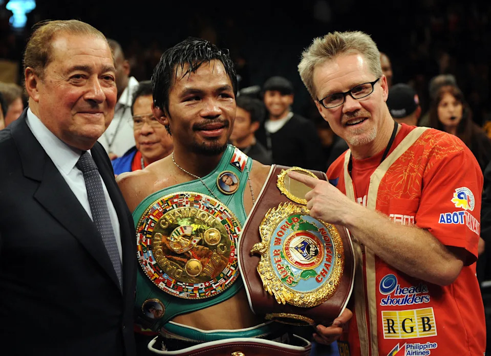 Manny Pacquiao of the Philippines (C) poses for a photo with promoter Bob Arum (L) and trainer Freddie Roach after defeating Miguel Cotto of Puerto Rico in a WBO welterweight title fight at the MGM Grand Garden Arena in Las Vegas, Nevada November 14, 2009. AFP PHOTO / GABRIEL BOUYS (Photo credit should read GABRIEL BOUYS/AFP via Getty Images)