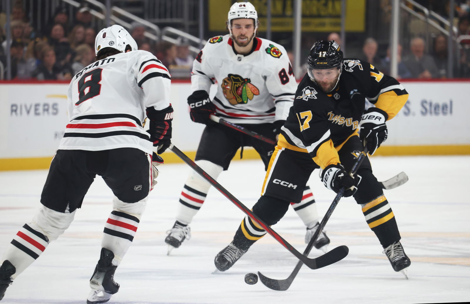 Apr 8, 2025; Pittsburgh, Pennsylvania, USA; Pittsburgh Penguins right wing Bryan Rust (17) moves the puck against Chicago Blackhawks center Ryan Donato (8) during the third period at PPG Paints Arena. Mandatory Credit: Charles LeClaire-Imagn Images
