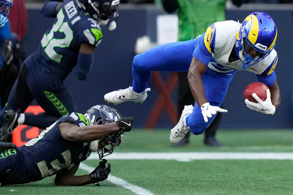 The Rams' Xavier Smith is tackled by the Seahawks' Dee Williams during a punt return.