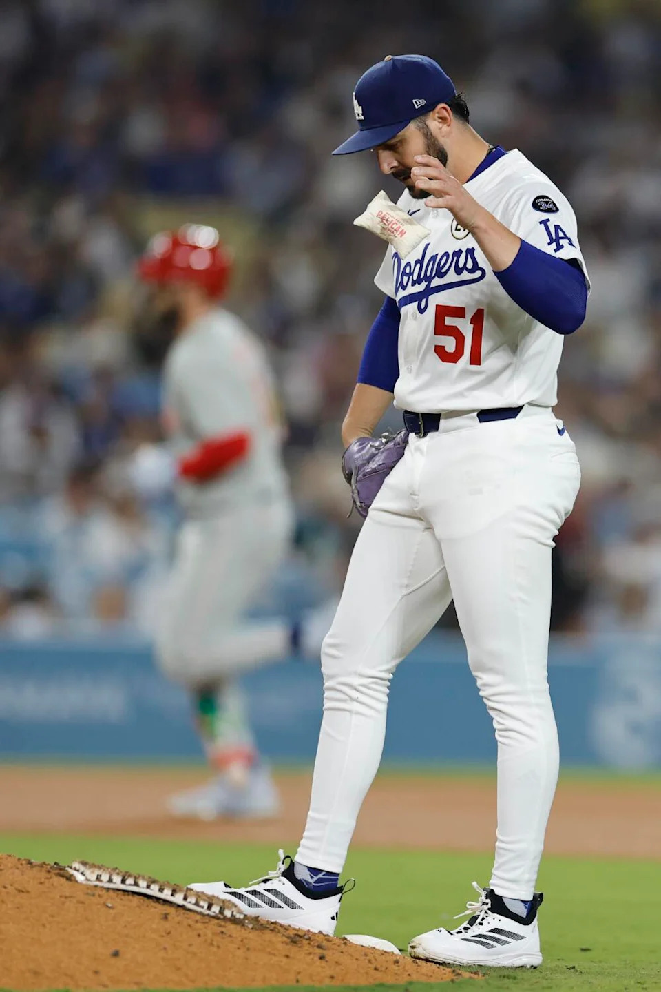 Dodgers pitcher Alex Vesia tosses a rosin bag in frustration after Phillies first baseman Bryce Harper homered.