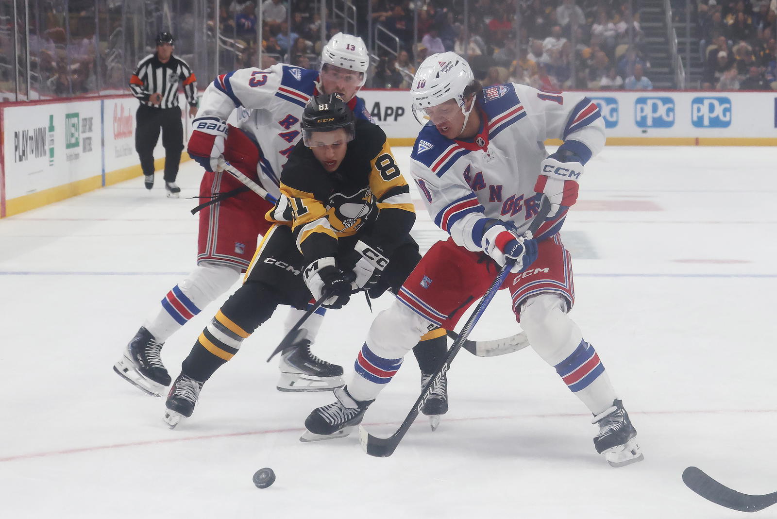 Oct 11, 2025; Pittsburgh, Pennsylvania, USA; Pittsburgh Penguins center Ben Kindel (81) and New York Rangers left wing Artemi Panarin (10) battle to control the puck during the second period at PPG Paints Arena. Mandatory Credit: Charles LeClaire-Imagn Images