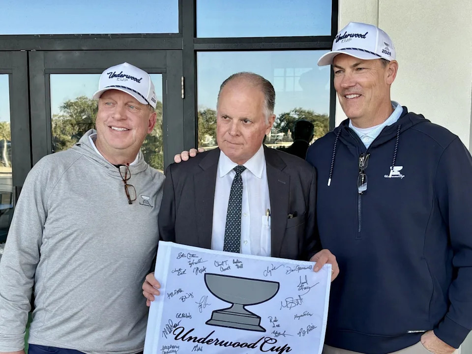 Underwood Cup 2026 captains Dean Grunewald of the professionals (left) and Steve Carter of the amateurs (right) present a pin flag signed by members of both teams following the matches at the Plantation at Ponte Vedra Beach on Feb. 3.