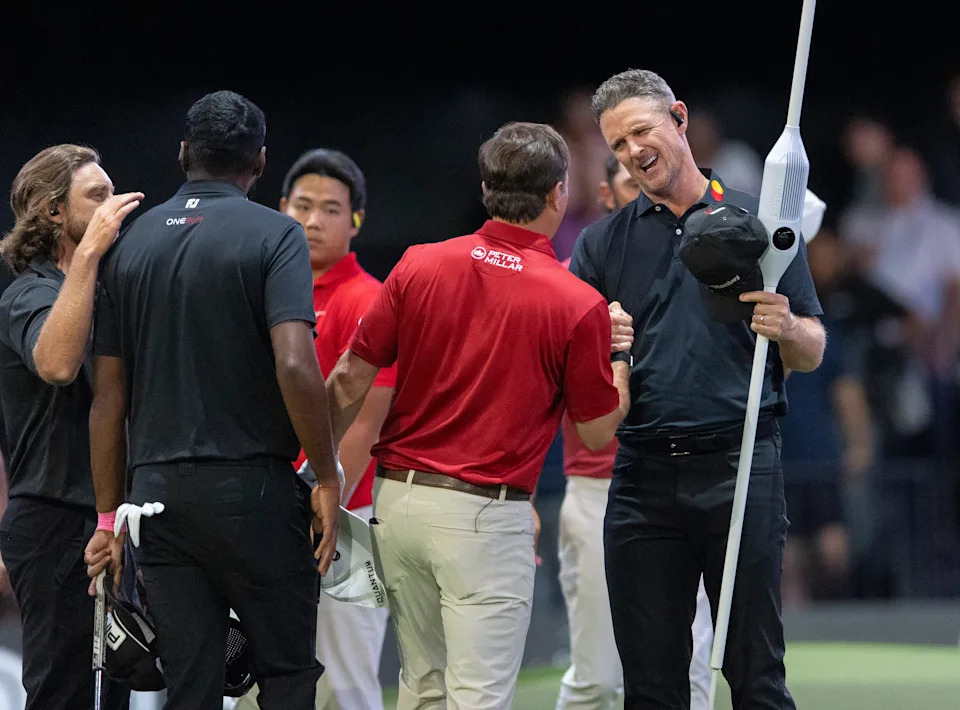 Justin Rose of Los Angeles Golf Club, rights, shakes hands with Kevin Kisner of of Jupiter Links GC after winning the first match in the TGL finals at SoFi Center on March 23, 2026, in Palm Beach Gardens, Florida.