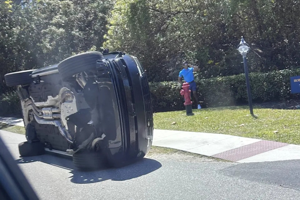Tiger Woods stands near his flipped Land Rover in Jupiter Island, Fla. on March 27, 2026. AP