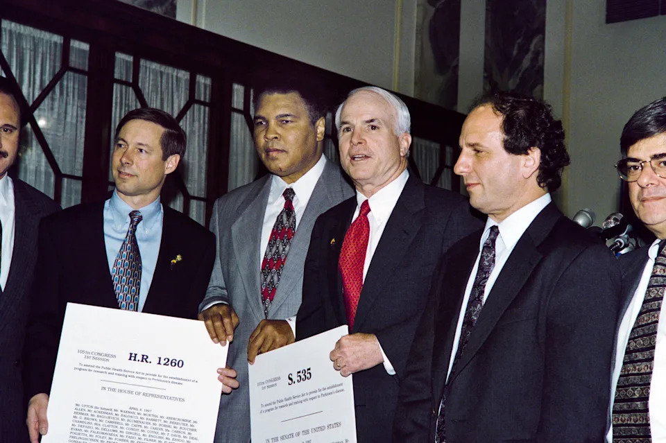 Former US heavyweight boxing champion Muhammad Ali (2nd-L) poses on April 23, 1997 with US Senators John McCain (2nd-R), and Paul Wellstone (R), D-MN, and Rep. Fred Upton (L), R-MI, during a visit to Capitol Hill in Washington where he testified before the House Appropriations Committee. Ali, who suffers from Parkinson's Disease, spoke to lawmakers to urge them to pass the Morris K. Udall Parkinson's Research Bill. The research funding was established in honor of former US Senator Udall who also suffers from the disease. AFP PHOTO Jim COLBURN (Photo by JIM COLBURN / AFP) (Photo by JIM COLBURN/AFP via Getty Images)