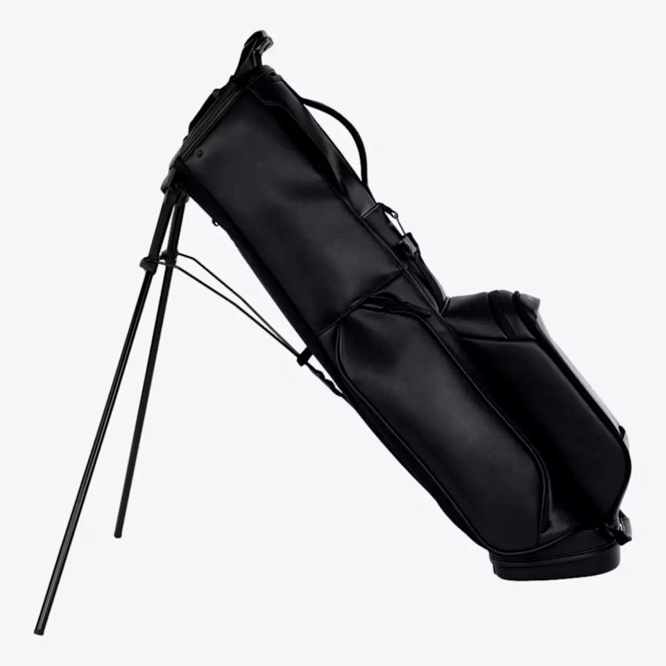 A black golf bag with built-in stand legs extended, positioned upright at an angle on a plain white background—an example of the best golf bags 2026 has to offer.