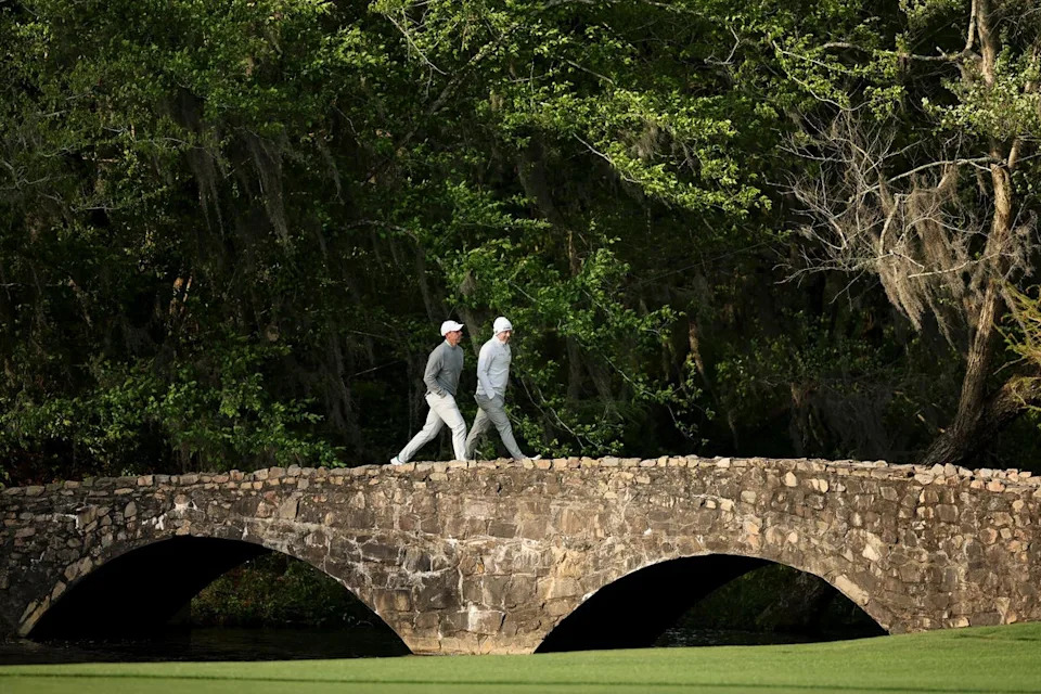 Rory McIlroy and Matt Fitzpatrick walk over the Nelson Bridge on the 13th hole during practice (Getty)
