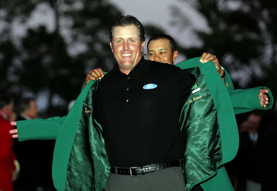 AUGUSTA, GA - APRIL 09:  Tiger Woods puts the green jacket on Phil Mickelson after Mickelson won The Masters at the Augusta National Golf Club after the final round on April 9, 2006 in Augusta, Georgia.   Mickelson won with the score seven under.  (Photo by Harry How/Getty Images)