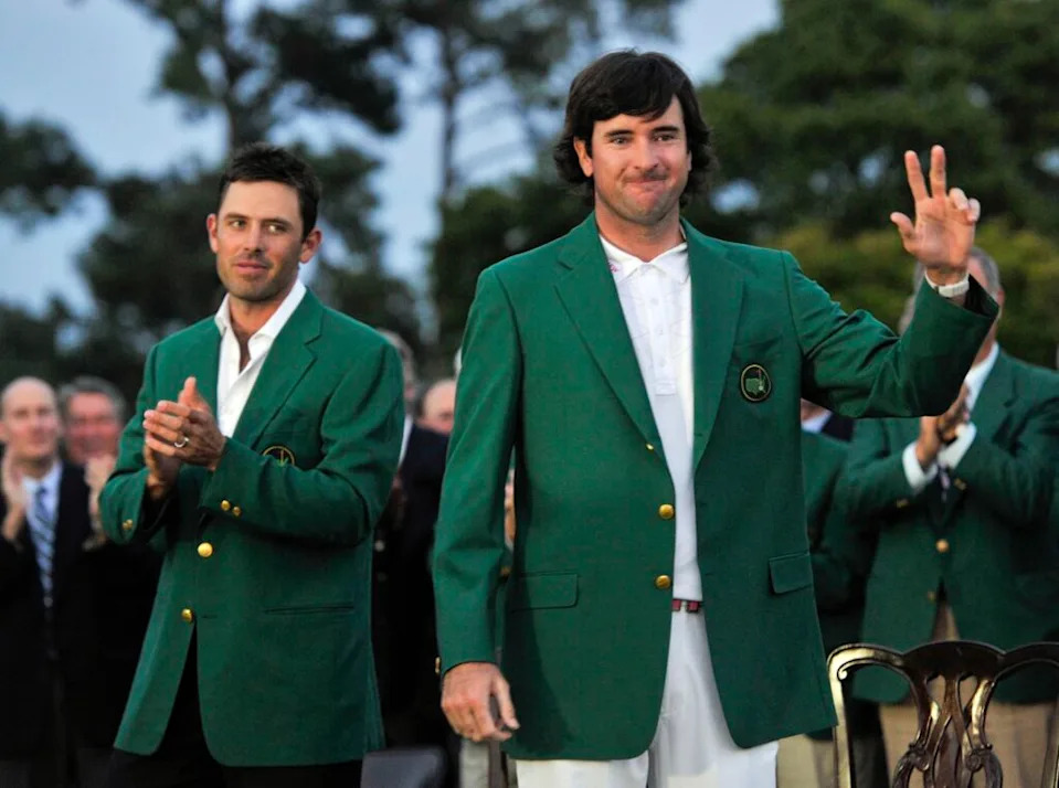 Apr 8, 2012; Augusta, GA, USA; Bubba Watson (right) reacts after being presented with the green Masters champion jacket from 2011 winner Charl Schwartzel (left) after the 2012 The Masters golf tournament at Augusta National Golf Club.  Mandatory Credit: Jack Gruber-USA TODAY Sports