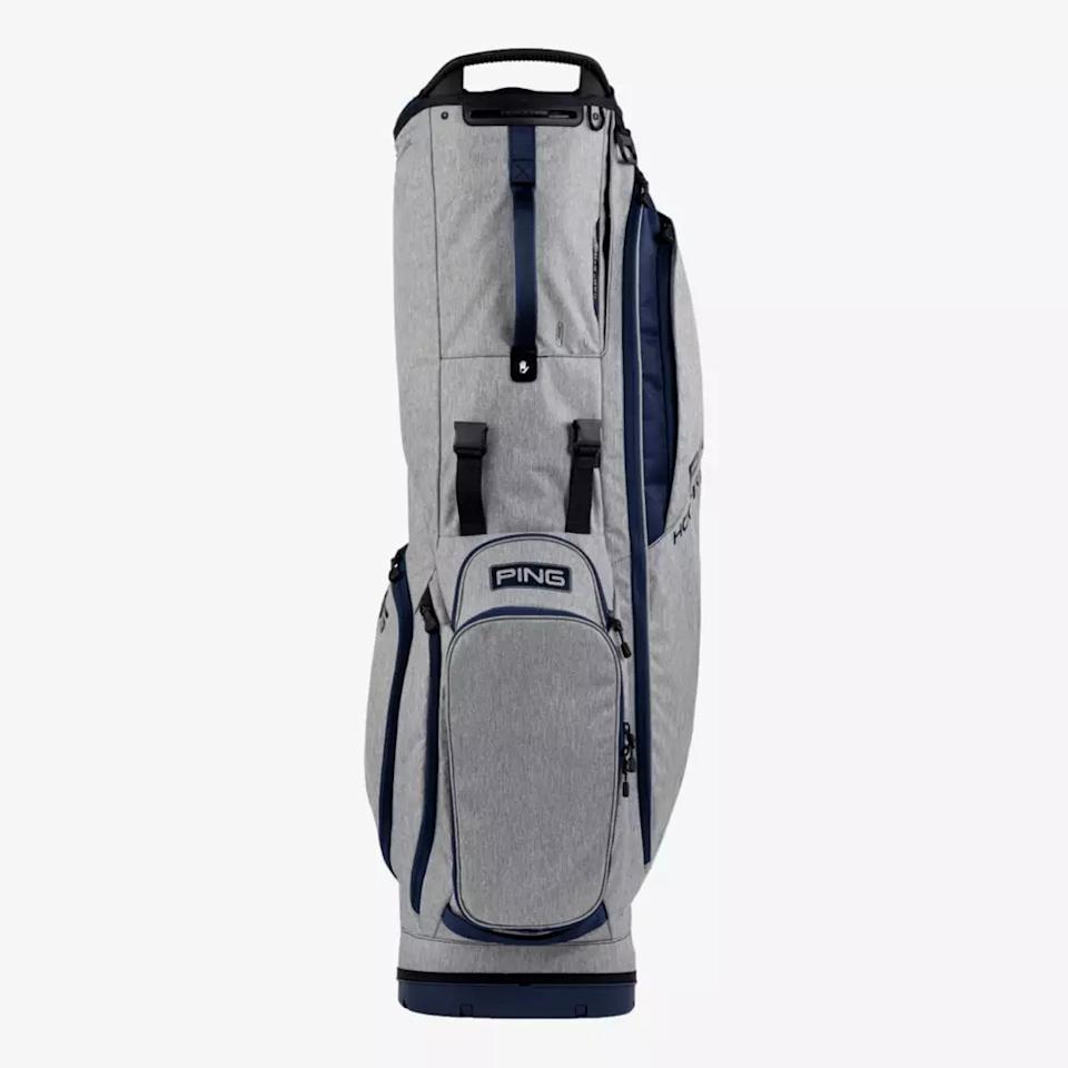 A gray and navy blue PING golf bag stands upright on a white background, featuring multiple zippered pockets, handles, and a sturdy design—perfect for golfers seeking one of the best golf bags 2026 has to offer.