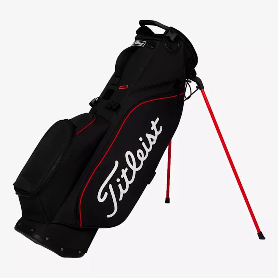 A black Titleist golf stand bag with red accents, side pocket, and two red legs extended for support is displayed against a plain white background—an ideal pick among the best golf bags 2026.