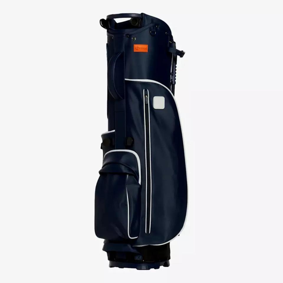 A navy blue golf bag with white trim, multiple zippered pockets, and a handle on top, standing upright against a plain light background—an ideal contender among the best golf bags 2026.