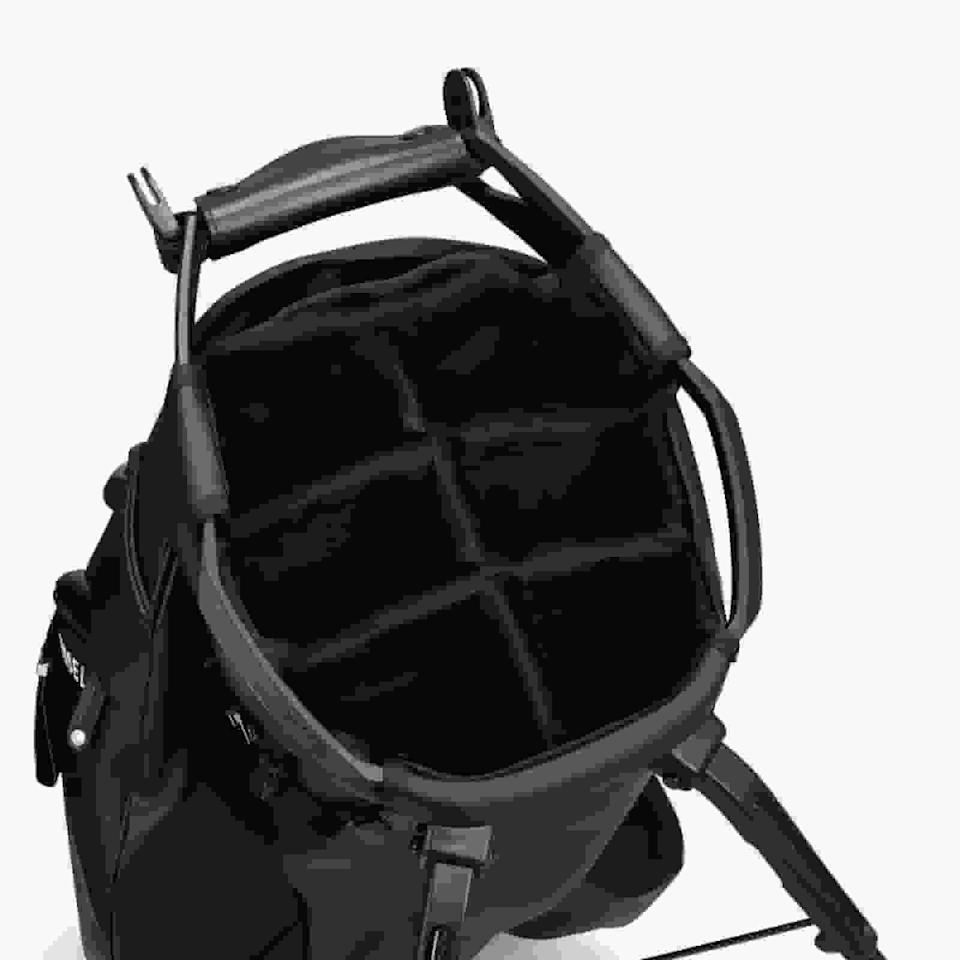 A black camera backpack with the main compartment open, revealing padded, adjustable dividers for organizing camera gear—offering versatility and smart design inspired by the best golf bags 2026. Features comfortable shoulder straps and a sturdy top handle.