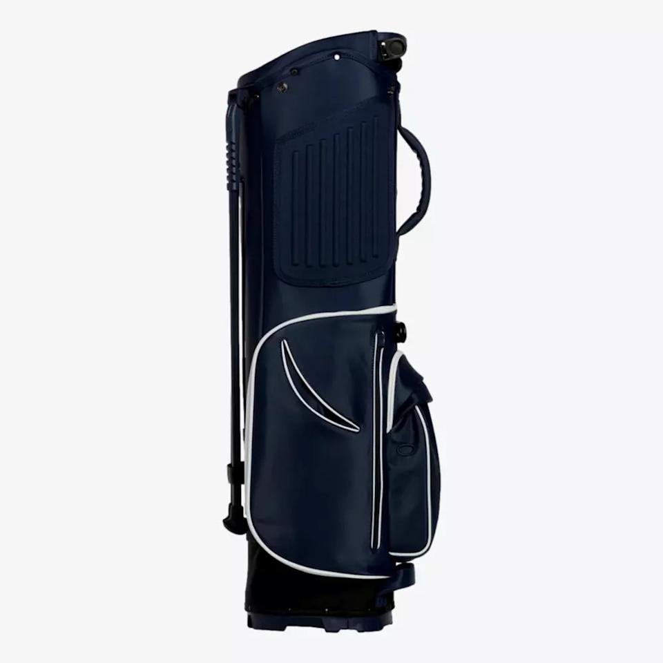 A navy blue golf bag with white trim, featuring a side handle, zippered pockets, and a stand—an excellent choice for those seeking one of the best golf bags 2026. The bag is upright and photographed against a plain light gray background.