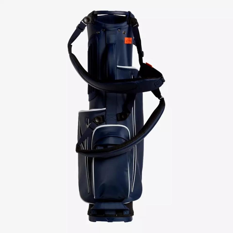 A navy blue golf bag with multiple zippered pockets, white trim accents, and a padded shoulder strap stands upright against a plain white background—an ideal choice for those seeking the best golf bags 2026.