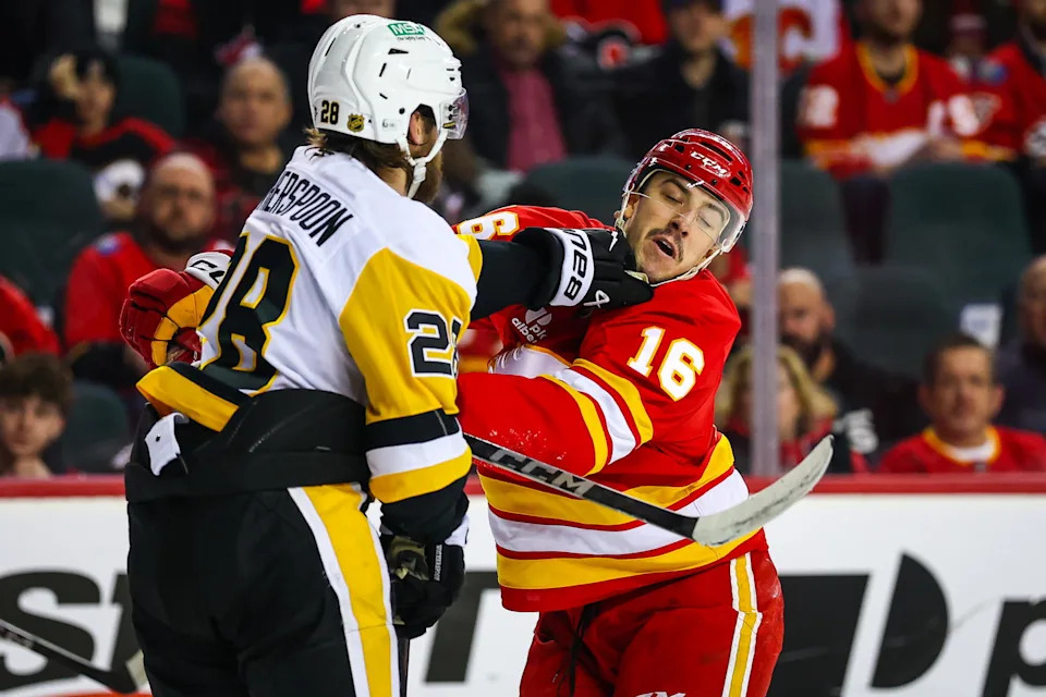 Jan 21, 2026; Calgary, Alberta, CAN; Calgary Flames center Morgan Frost (16) and Pittsburgh Penguins defenseman Parker Wotherspoon (28) get into a scrum during the second period at Scotiabank Saddledome. Mandatory Credit: Sergei Belski-Imagn Images