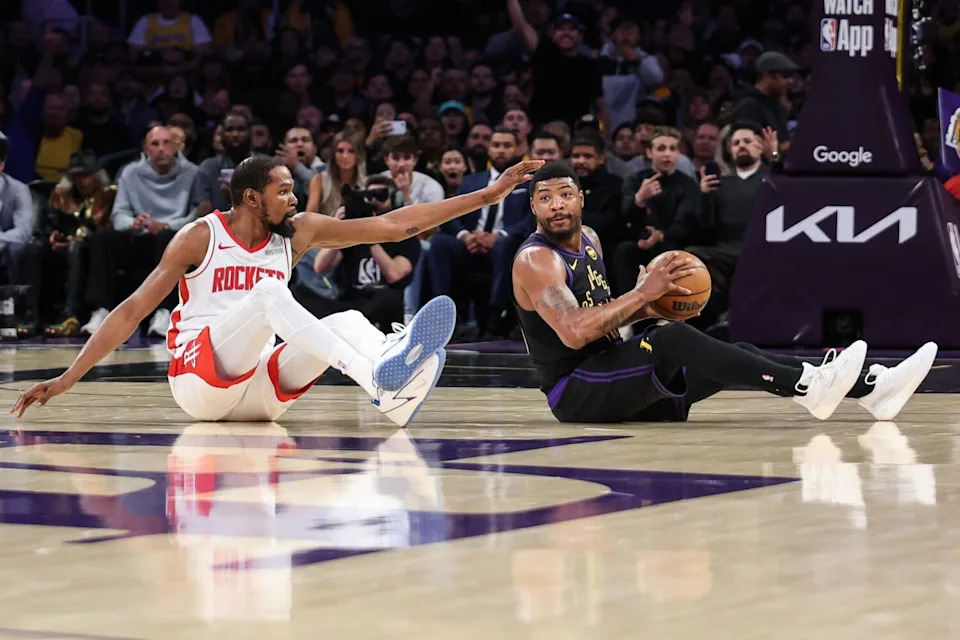 Lakers guard Marcus Smart sits on the floor with the basketball after poking it away from Houston forward Kevin Durant.