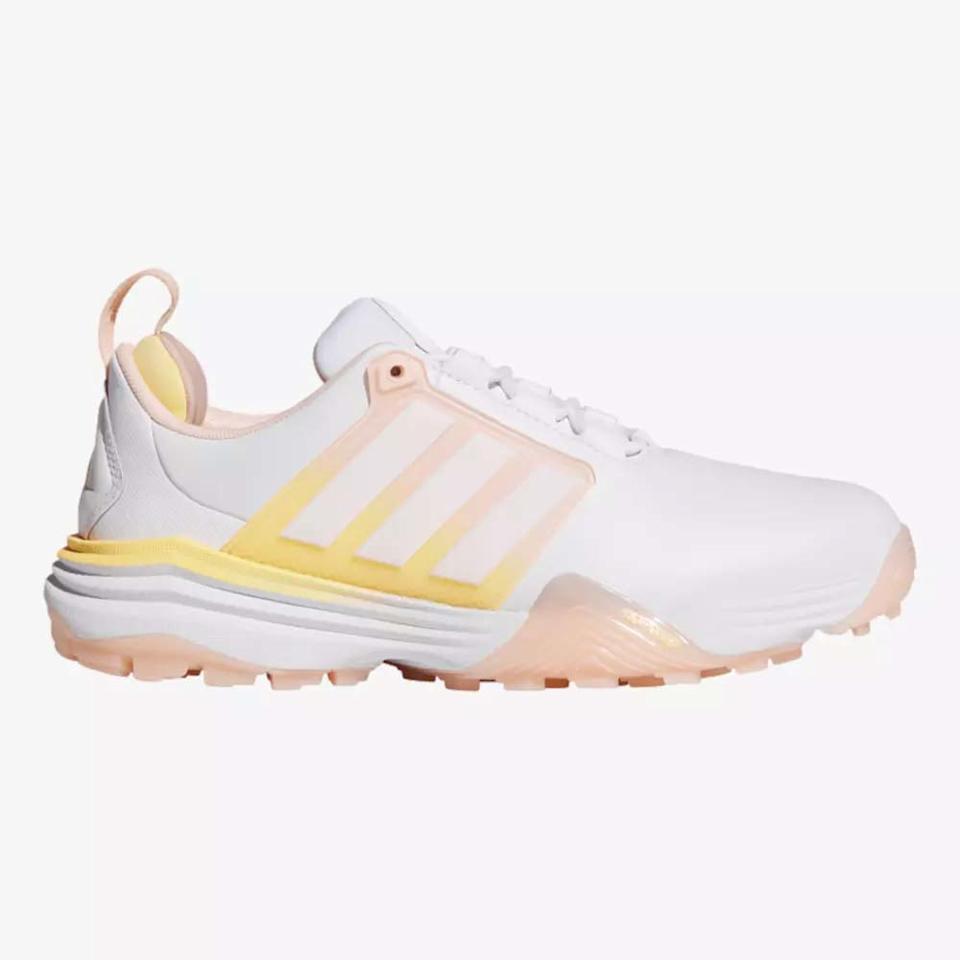 A white athletic shoe with light pink and yellow accents, featuring three pale pink stripes on the side, a textured sole, and a pull tab at the heel—perfect shoes for both style and comfort.