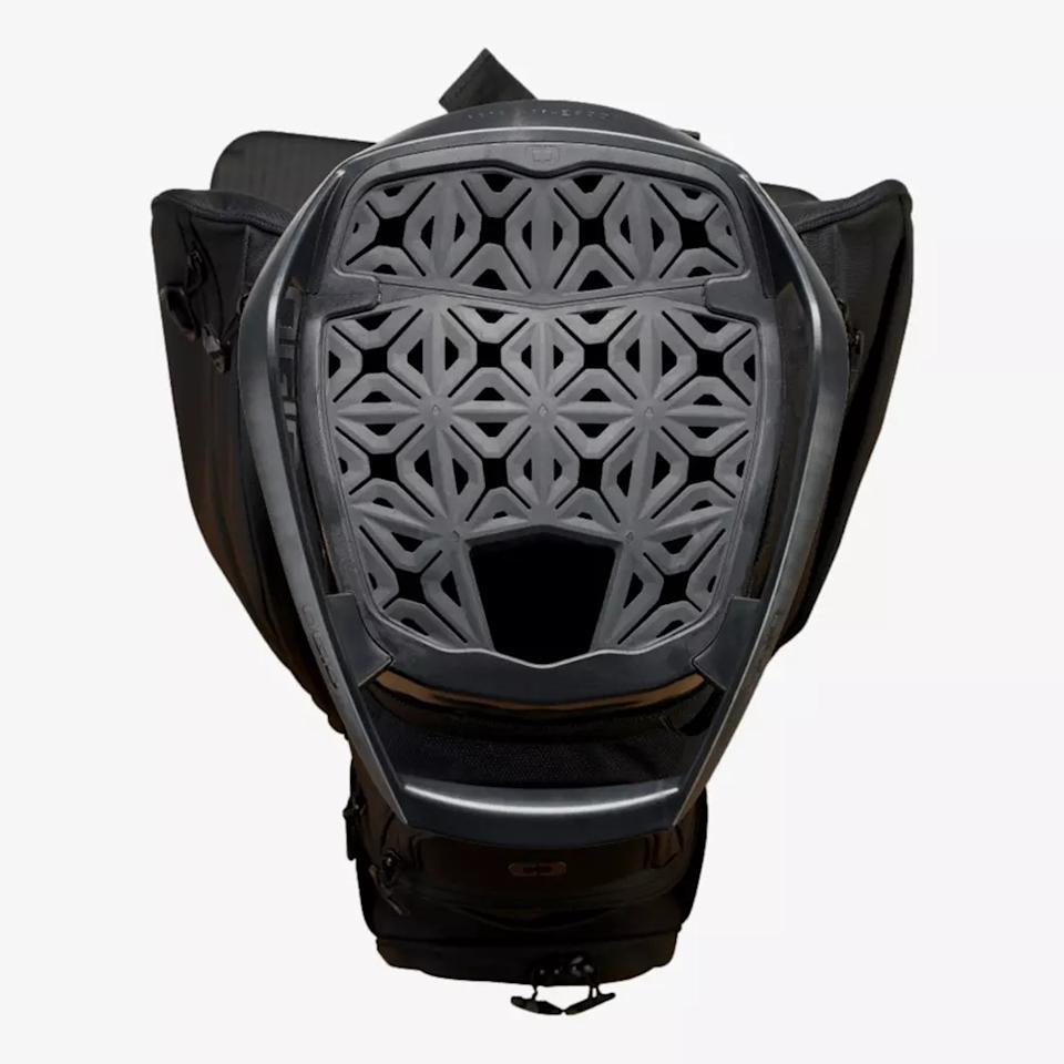 A black backpack with the top open, revealing a geometric, lattice-patterned back panel for ventilation and support—similar to the innovative designs seen in the best golf bags 2026. Interlocking shapes and an open area at the bottom center enhance airflow.