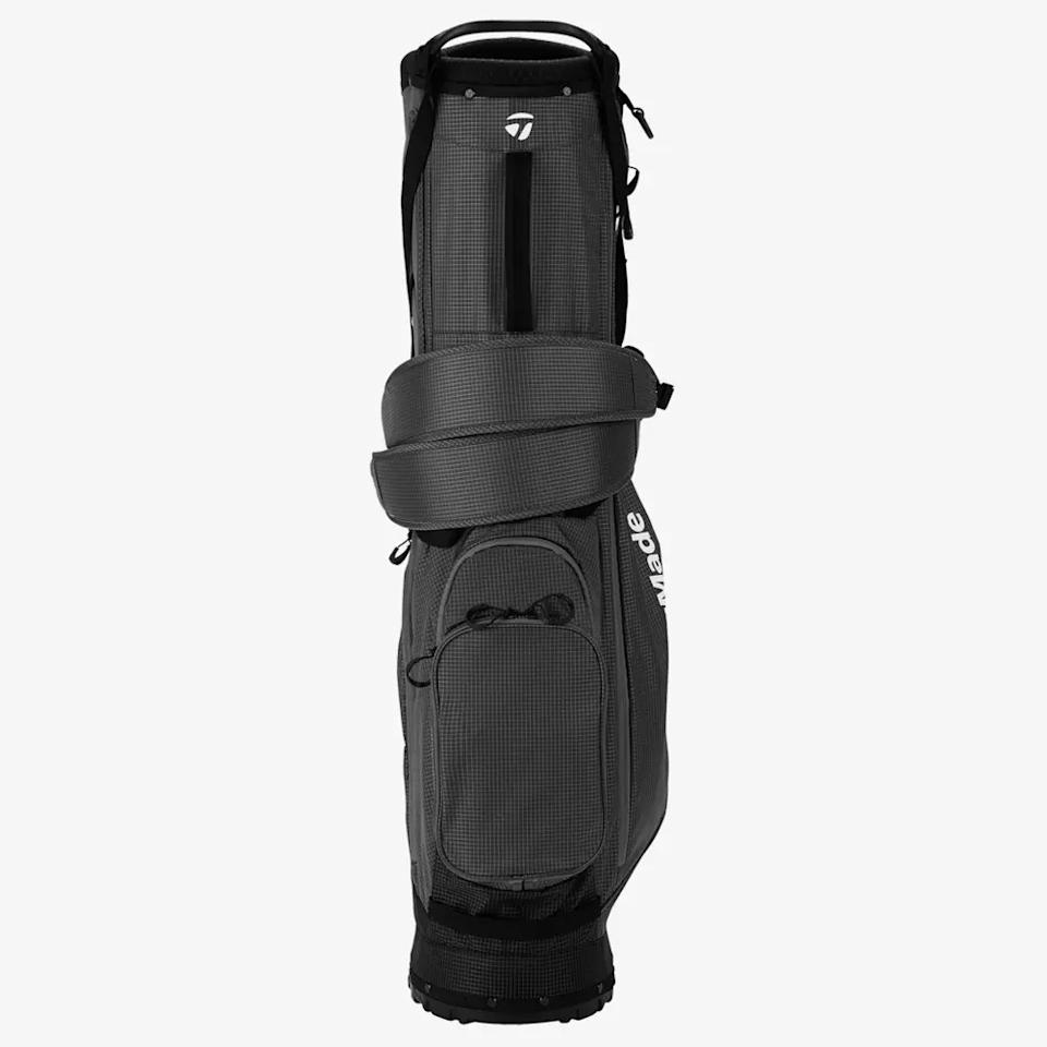 A black and gray golf bag with zippered pockets, shoulder straps, and the word “TaylorMade” printed vertically in white on the side—an ideal pick for anyone searching for the best golf bags 2026.