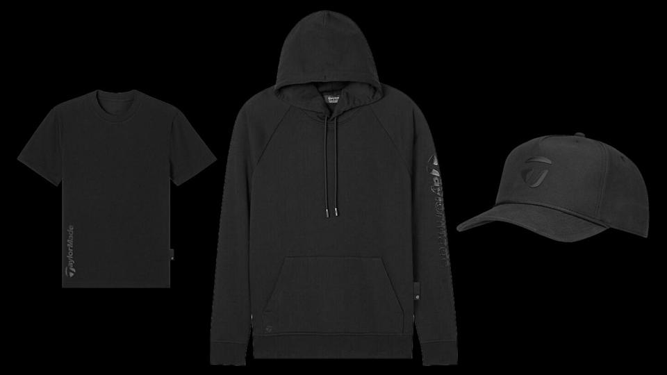 A black t-shirt, black hoodie with front pocket and drawstrings, and a black baseball cap featuring subtle TaylorMade branding, all displayed on a black background.