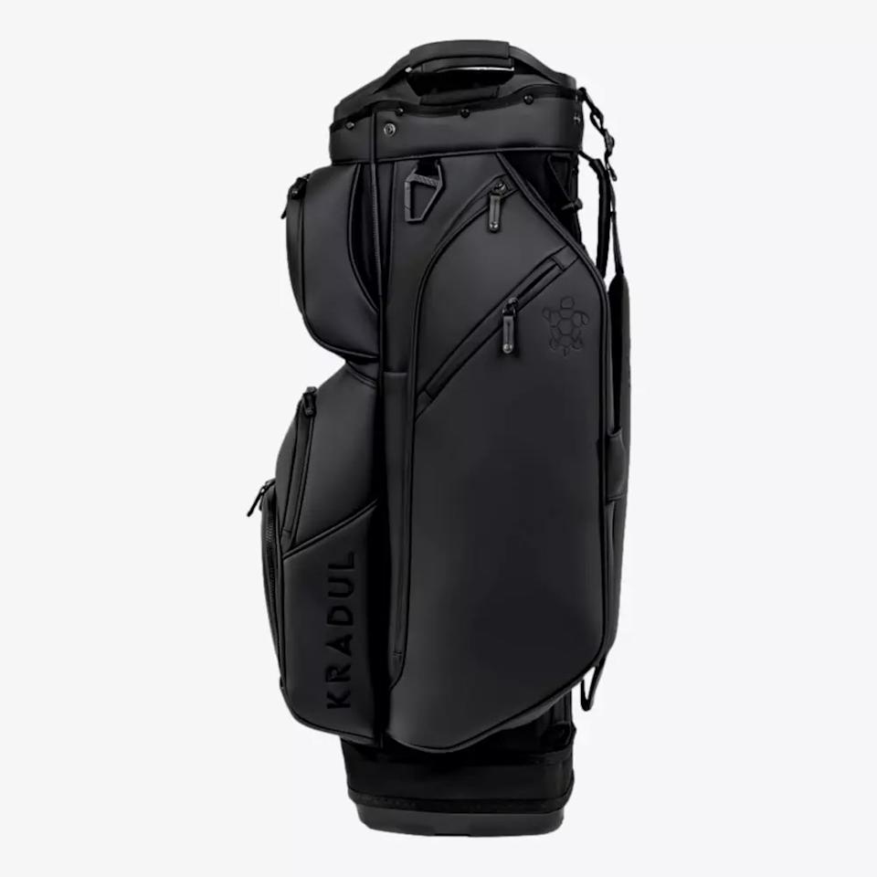 A sleek, black KRADUL golf bag—one of the best golf bags 2026—with multiple zippered compartments, a top carry handle, and a subtle logo on the upper pocket, shown standing upright against a plain white background.