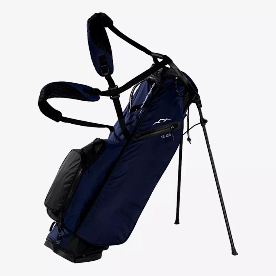 A navy blue golf stand bag, featured among the best golf bags 2026, with black straps and multiple zippered pockets, rests on extended legs against a plain white background.