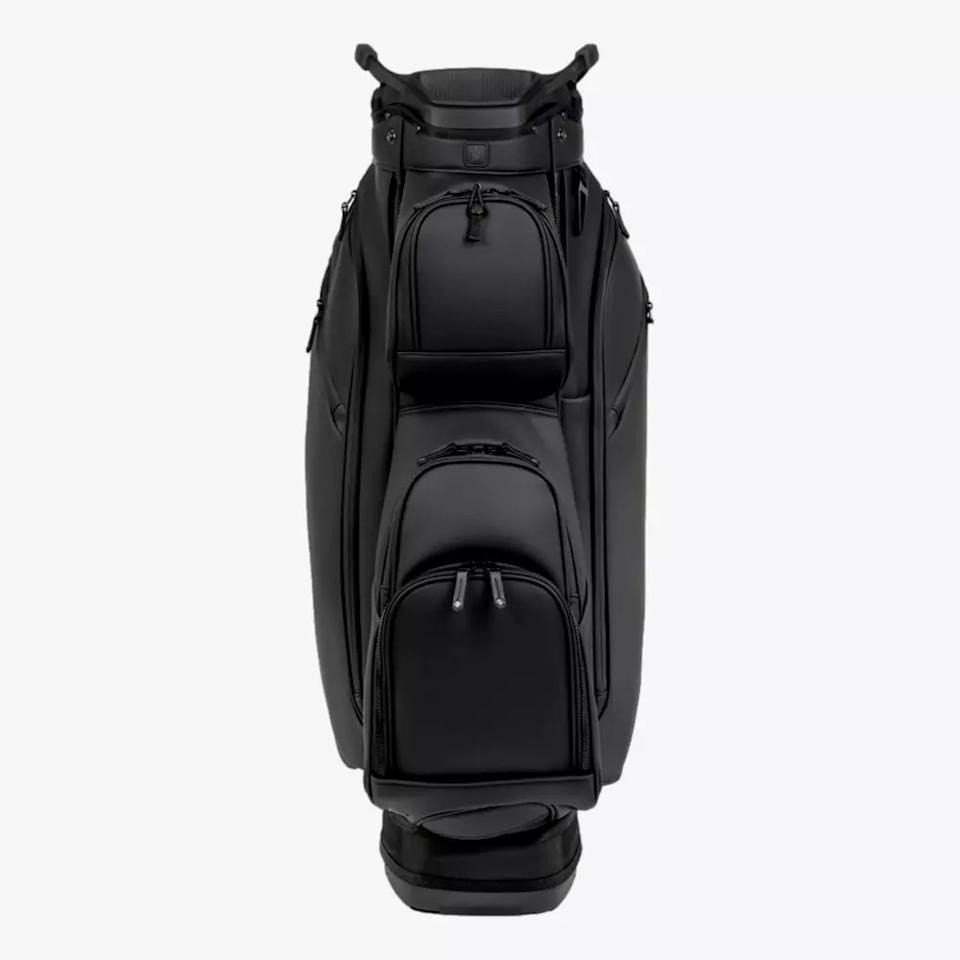 A black golf bag with multiple zippered pockets and a sturdy handle, shown standing upright against a plain white background—an ideal choice among the best golf bags 2026 has to offer.