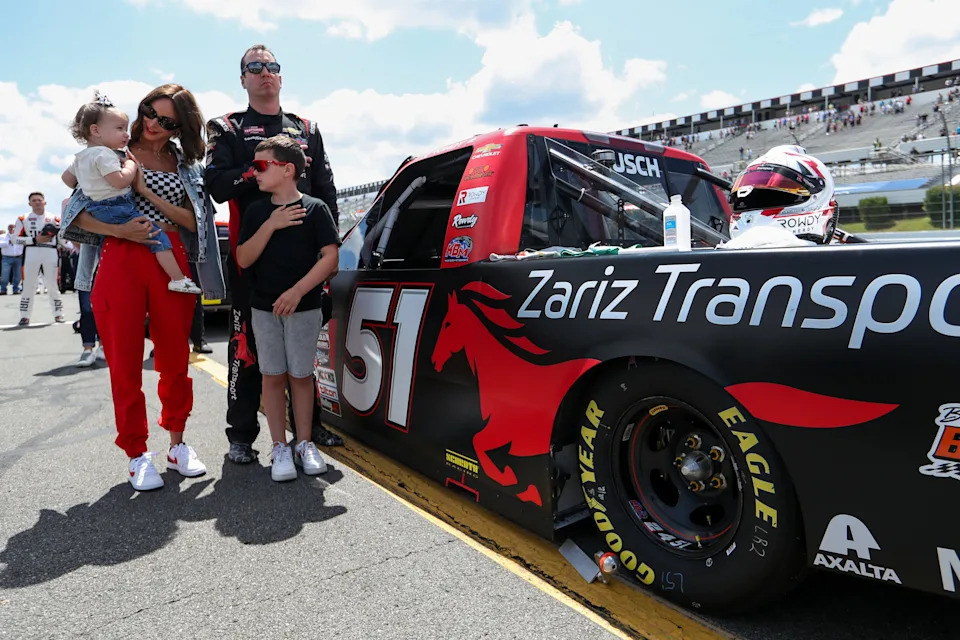 NASCAR Craftsman Truck Series driver Kyle Busch stands with his wife Samantha Busch and children Brexton and Lennix prior to the CRC Brakleen 150 at Pocono Raceway in 2023.