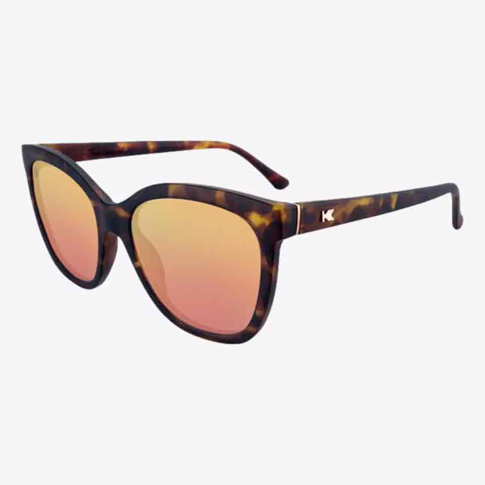 Tortoiseshell cat-eye sunglasses with pink mirrored lenses and a small metallic logo on the left temple, shown on a white background—perfect stylish accessories or thoughtful Mother’s Day gifts.