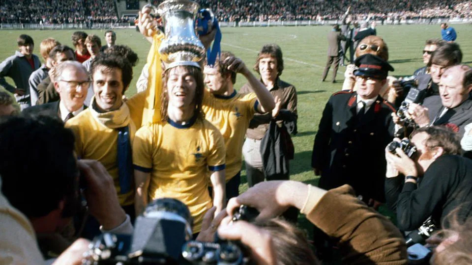 Charlie George with the FA Cup trophy on his head