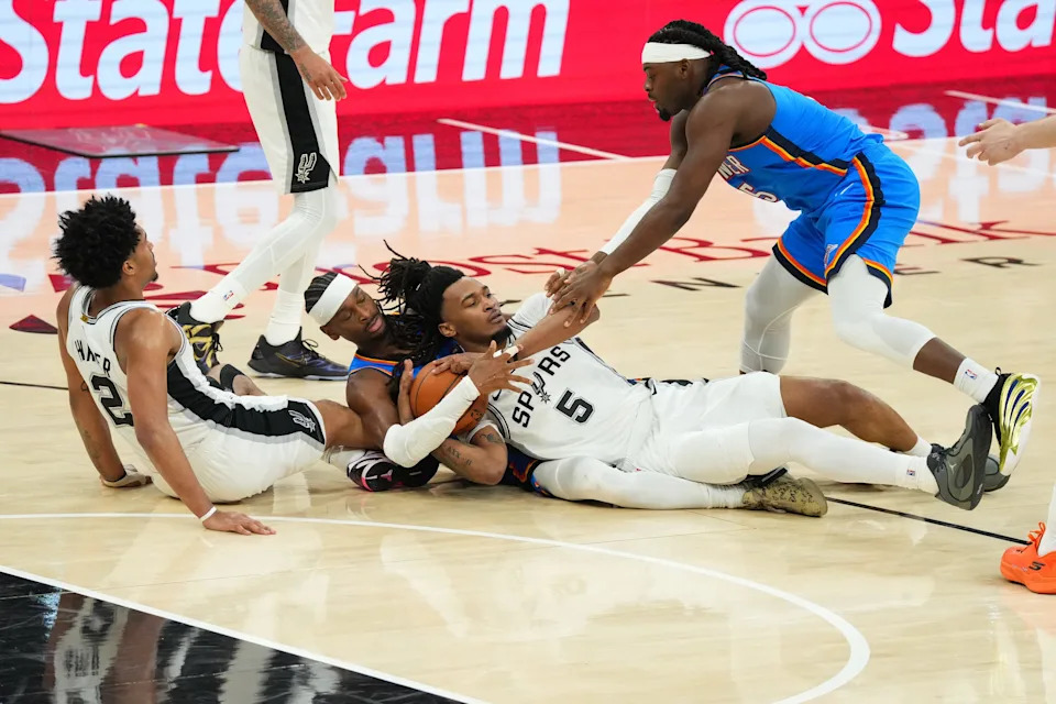 The Spurs' Dylan Harper (2), Stephon Castle (5) and Thunder's Shai Gilgeous-Alexander (2) and Luguentz Dort (5), scramble for a loose ball during Game 4 at Frost Bank Center.