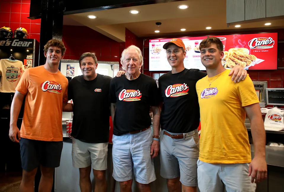 Arch Manning, CEO of Raising Cane's Chicken Fingers, Todd Graves, Archie Manning, Cooper Manning, and Garrett Nussmeier work a Pre-Manning Passing Academy "Shift" at Raising Cane's Thibodeaux, Louisiana on June 26, 2025 in New Orleans, Louisiana. 